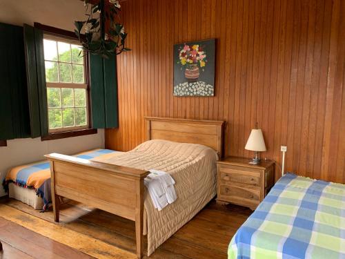 a bedroom with two twin beds and a window at Pouso dos Sinos in Ouro Preto