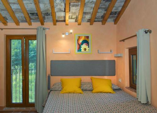 a bedroom with a bed with two yellow pillows at Dolce Vita in Tuscany B&B in Capannori