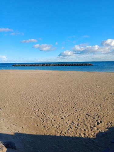 una playa con huellas en la arena y el océano en Studio Cap d'Agde le Môle en Cap d'Agde