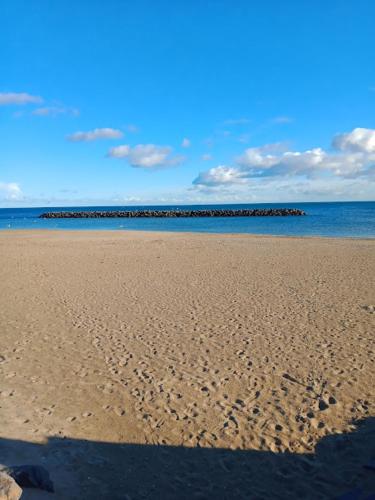 a beach with footprints in the sand and the ocean at Studio Cap d'Agde le Môle in Cap d'Agde