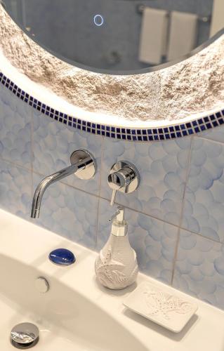a sink in a bathroom with a mirror at Villa dei Lecci - 7 Luxury villas with private pool or jacuzzi in Ischia