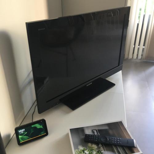 - une télévision à écran plat assise sur une table avec télécommande dans l'établissement Le Studio Central Park, à Cannes