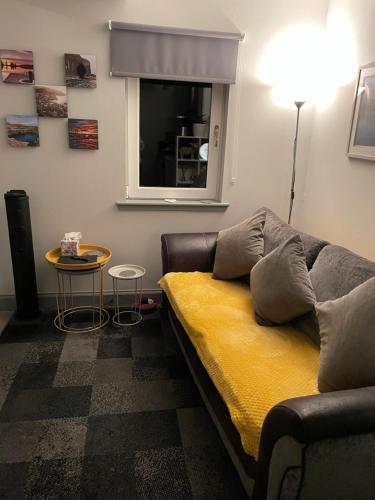 ein Wohnzimmer mit einem Sofa, einem Tisch und einem Fenster in der Unterkunft Burnside in Oban