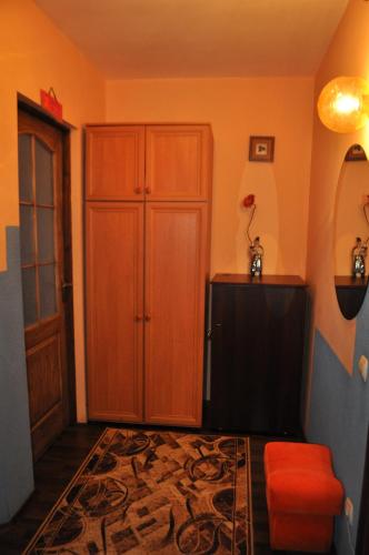 Habitación con armario de madera y taburete rojo. en Spacious apartment with balcony, en Kremenchuk