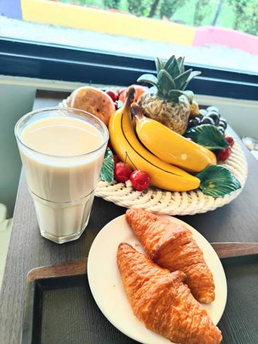 a table with a plate of bread and a glass of milk at Xinyuanbao Shangshi Homestay in Donggang