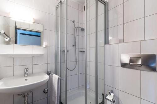 a white bathroom with a shower and a sink at Landhotel zum kühlengrund & soultans paradise in Brensbach