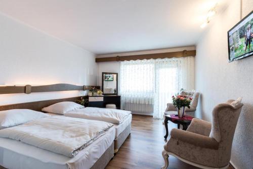 Habitación de hotel con 2 camas y sofá en Landhotel zum kühlengrund & soultans paradise en Brensbach