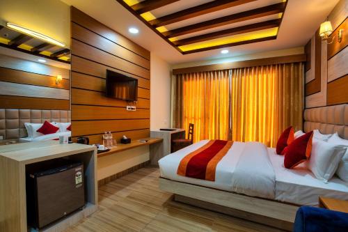 una camera d'albergo con letto e TV di Chitwan Mid Town Resort a Bharatpur