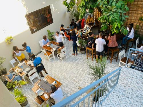 a group of people sitting at tables in a restaurant at Cole Street Guesthouse in Freetown