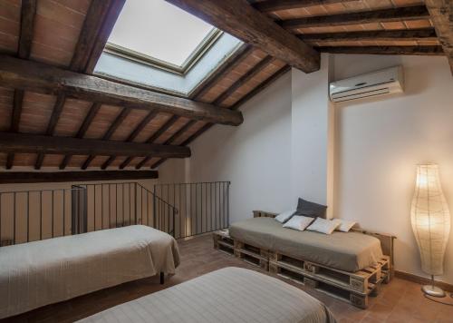 a bedroom with two beds and a ceiling with a window at Casa Vacanze Le Fornaci in Laterina