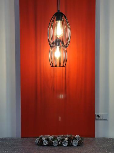 a chandelier hanging over a table in front of a red wall at Немного Лондона в центре Чернигова in Chernihiv