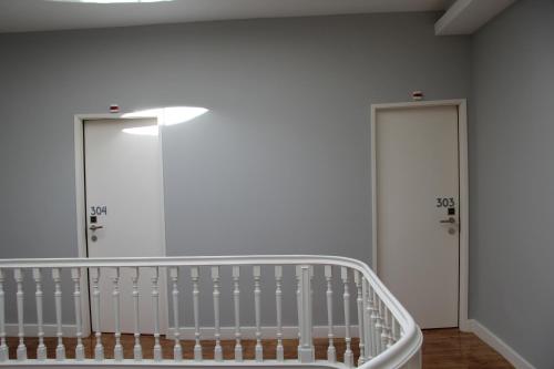 a white room with two doors and a staircase at Decanting Porto House in Porto