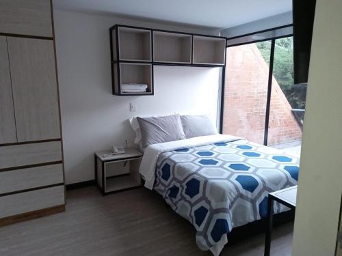 a small bedroom with a bed and a window at Terrazas in Bogotá