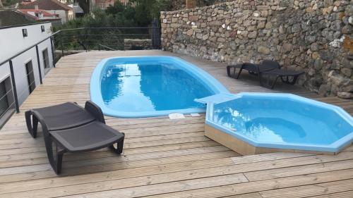 a lap pool on a deck with a chair and a bench at Casa da Roda - Turismo de Habitação in Pinhel