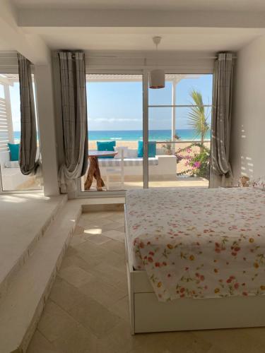 a bedroom with a bed and a view of the ocean at Villa Nº25b Alfredo Marchetti suites on the beach Praia di Chaves in Cabeçadas