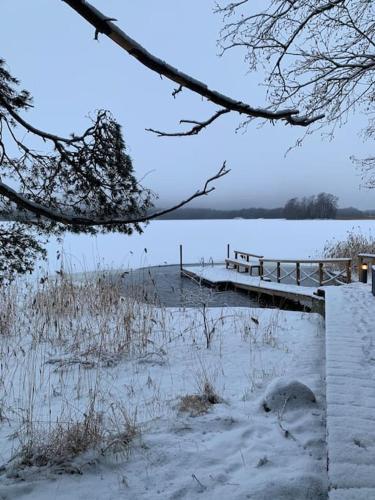 a snow covered bridge over a body of water at Villa Korppi in Jorvas