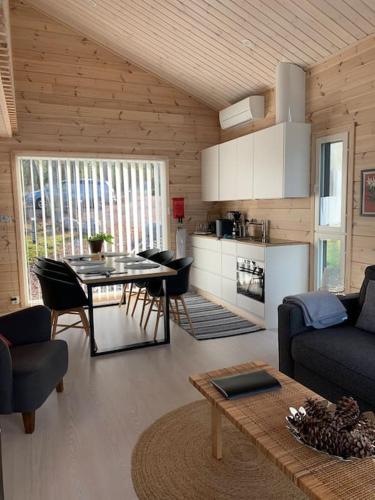 a living room with a table and a kitchen at Villa Korppi in Jorvas