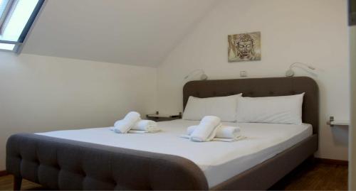 a bedroom with a bed with two white towels on it at ANEMOMYLOS Lefkimmi LUXUS SUITES-BOUTIQUE HOTEL & POOL in Lefkímmi