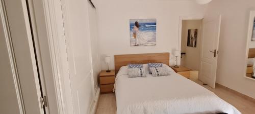 a bedroom with a white bed with blue pillows at Villa D&D in Torrox Costa