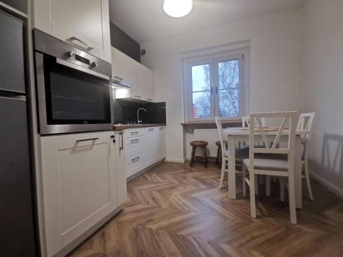eine Küche mit einem Esstisch und einem TV in der Unterkunft Apartament Black&White in Jelenia Góra