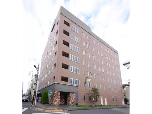 a large building on the corner of a street at R&B Hotel Kumagaya Ekimae - Vacation STAY 40476v in Kumagaya