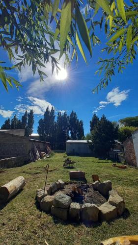 eine Feuerstelle mitten auf einem Feld in der Unterkunft Hostel Yatel in El Calafate