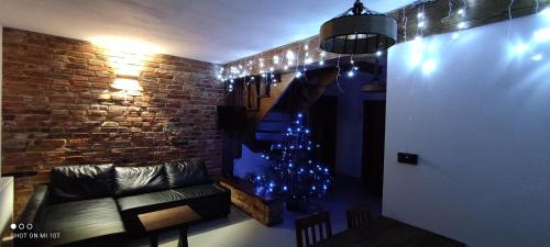 a living room with a christmas tree and a couch at Dom Gościnny Poza Czasem in Żubracze