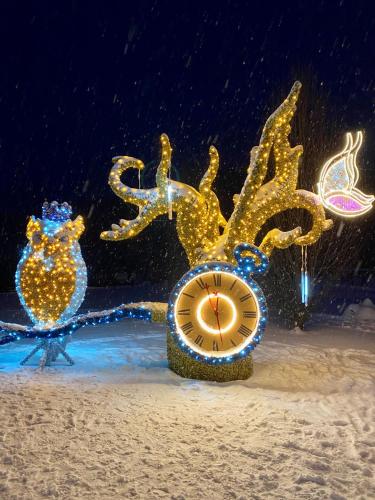 a christmas display of a clock in the snow at Apartament Muszyna in Muszyna