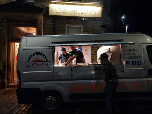 a food truck with three people preparing food in it at Trawden Arms Community Owned Pub in Winewall