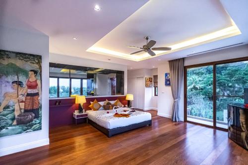 a bedroom with a bed and a ceiling fan at VILLA DIVA STAR in Ko Yao Noi