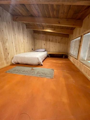 a small room with a bed in a wooden cabin at Pucontours River Lodge in Pucón