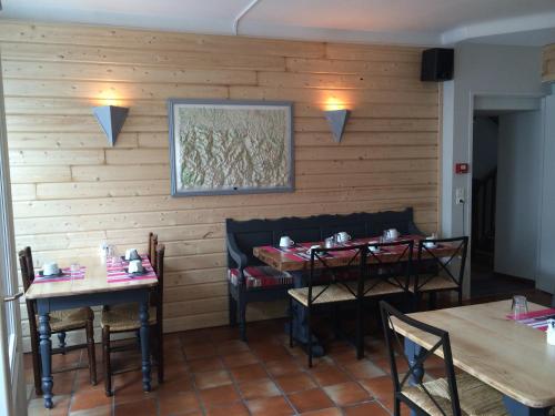 a restaurant with two tables and chairs and a painting on the wall at Hôtel des Cimes in Luz-Saint-Sauveur