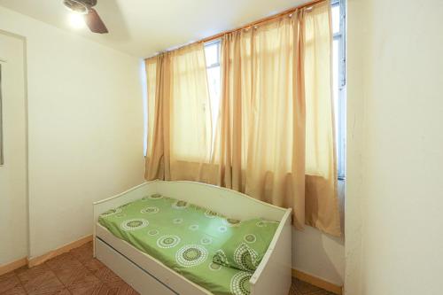 a bed in a room with a window at Apart a 450 metros da Praia de Ponta Negra RJ in Jaconé