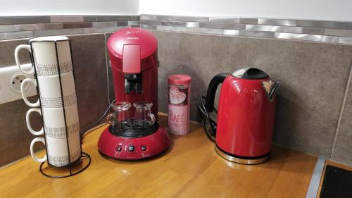 a red blender sitting on top of a wooden counter at Charmant appartement T2 dans villa avec en supplément spa extérieur de mai à septembre in Laveyron