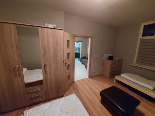 a bedroom with a large wooden cabinet with a mirror at Spalona Apartament Jagodna in Bystrzyca Kłodzka