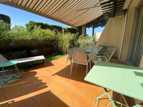un patio avec des tables et des chaises sur un patio dans l'établissement Tennis Village, au Cap d'Agde