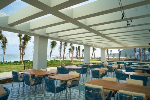 een restaurant met tafels en stoelen en het strand bij Ocean Eden Bay - Adults Only - All Inclusive in Spring Rises