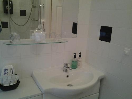 a white bathroom with a sink and a mirror at The Post House in Ibstock