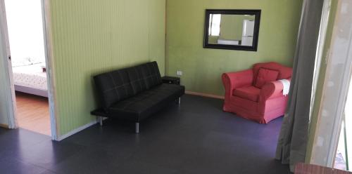 a living room with two chairs and a mirror at Cabañas El Toro - Radal Siete Tazas in Molina