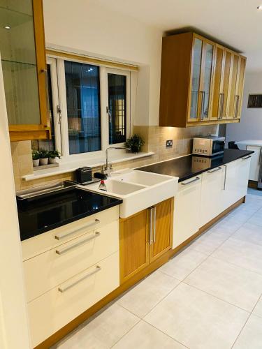 a kitchen with wooden cabinets and a sink at Castlebar in Great Singleton