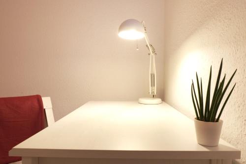 a table with a lamp and a potted plant on it at Ferienwohnung Heimaterde in Mülheim an der Ruhr