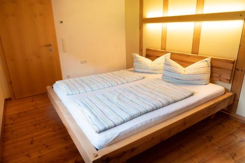 a bed with pillows on it in a room at Ferienhaus FuchsbAu in Au im Bregenzerwald