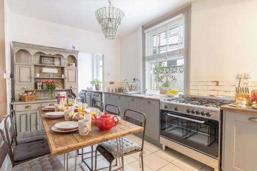 a kitchen with a wooden table and a stove at Sunnymead in Torquay