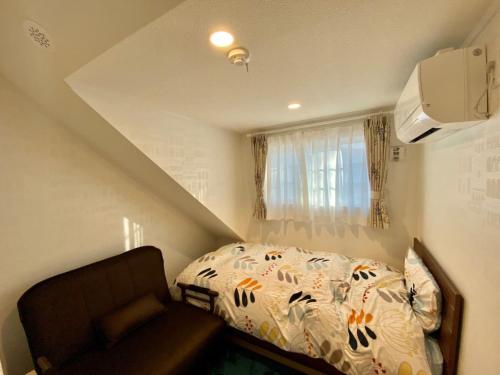 um pequeno quarto com uma cama e um sofá em Polar House ShinKaruisawa1 - Vacation STAY 00271v em Karuizawa