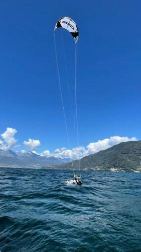a person in a boat in the water with a kite at Casa Artis in Gravedona