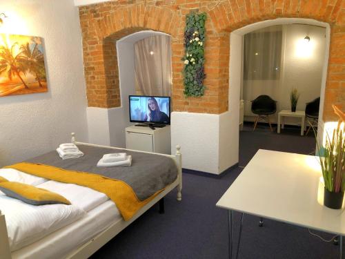 ein Schlafzimmer mit einem Bett und einem TV in einem Zimmer in der Unterkunft Great Polonia Jelenia Góra City Center in Jelenia Góra