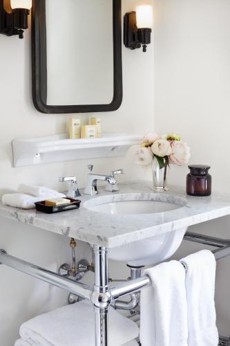 a bathroom with a sink and a mirror and towels at The High Line Hotel in New York