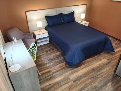 a bedroom with a bed and a desk and a chair at Hotel Boutique Quinta Camacho in Bogotá