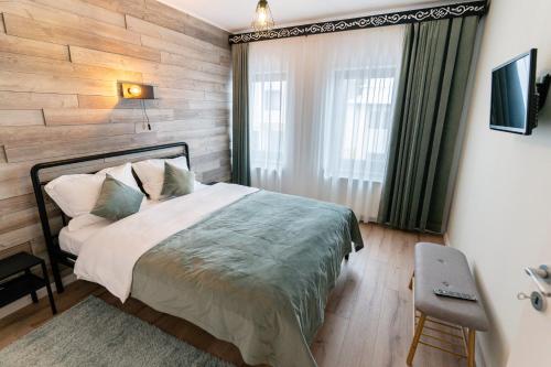 - une chambre avec un lit et un mur en bois dans l'établissement MyApartment, à Râșnov
