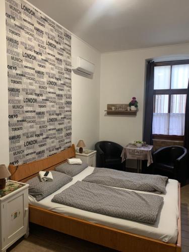 a bedroom with a bed with a wall covered in writing at Anna Apartman in Pápa
